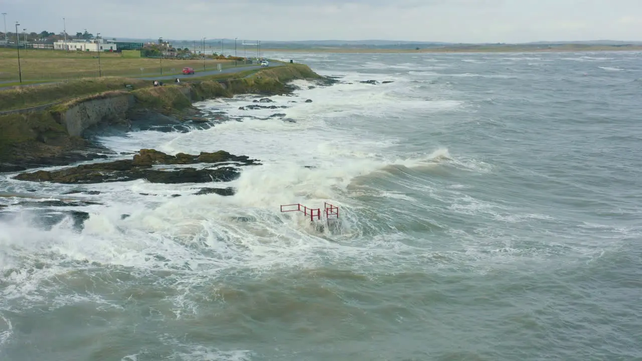 Aerial view of waves crashing against rocks along the coastline