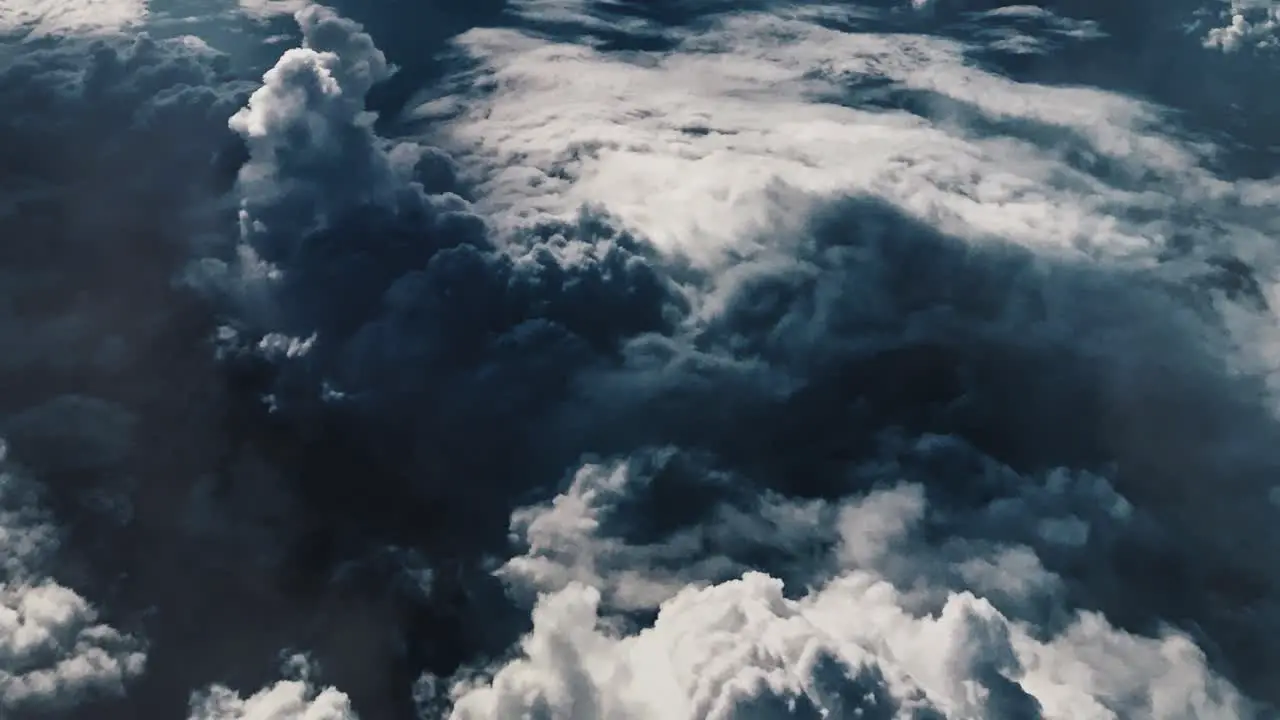 point of view from top bright dark cumulus clouds in the blue sky