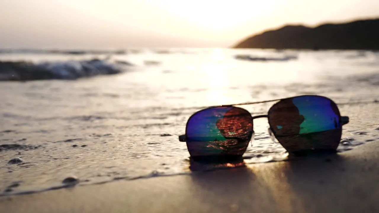 Sea waves washing over sunglasses under the sunny sun