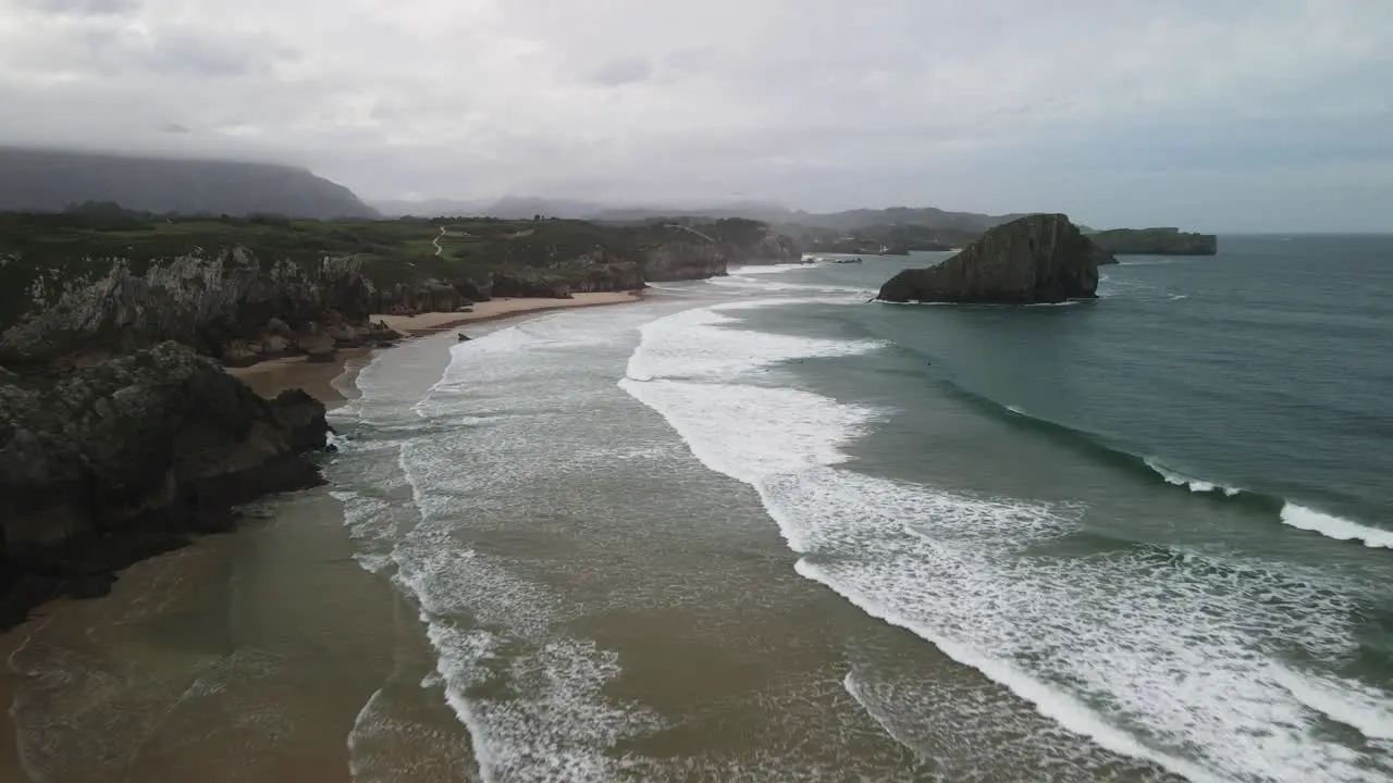 Ocean waves rolling in on Canabrian coast shoreline beach aerial view