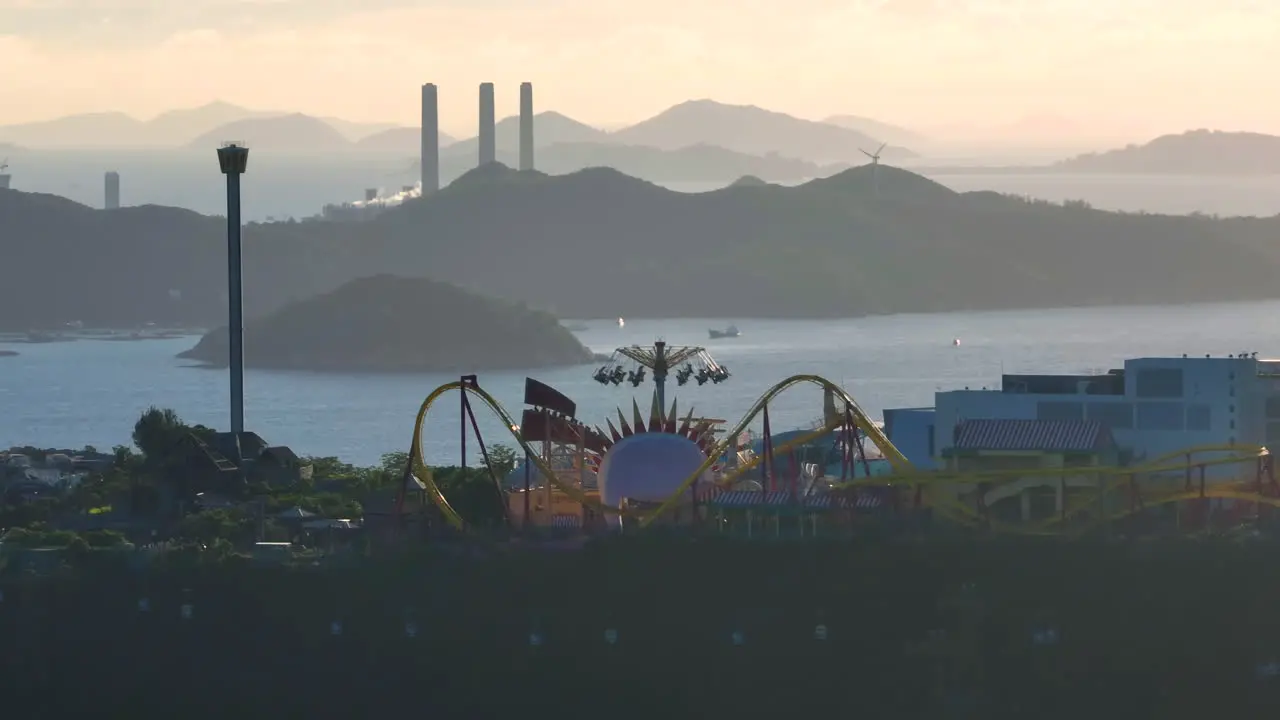 Aerial orbiting shot of Ocean Park in Hong Kong and Lamma Island power station in background at sunset