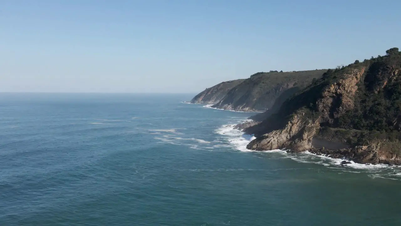 South Africa Wilderness Coast Green Mountains with Ocean Waves crashing on the rocks