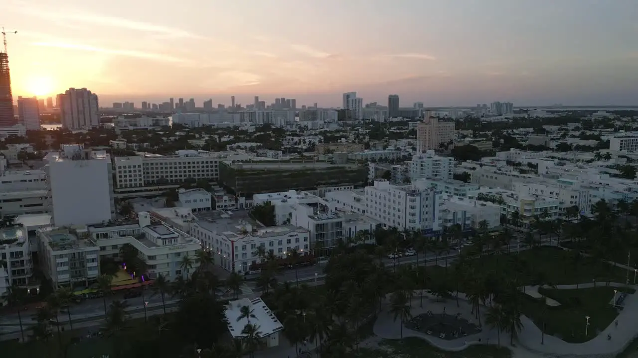 drone revealing ocean drive road with bar club and restaurant in Miami South beach during sunset