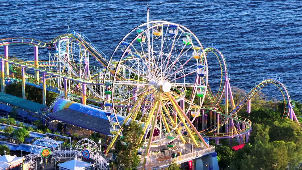 Orbiting aerial drone tele-lens shot of Ocean Park Ferris wheel with ocean in the background Hong Kong