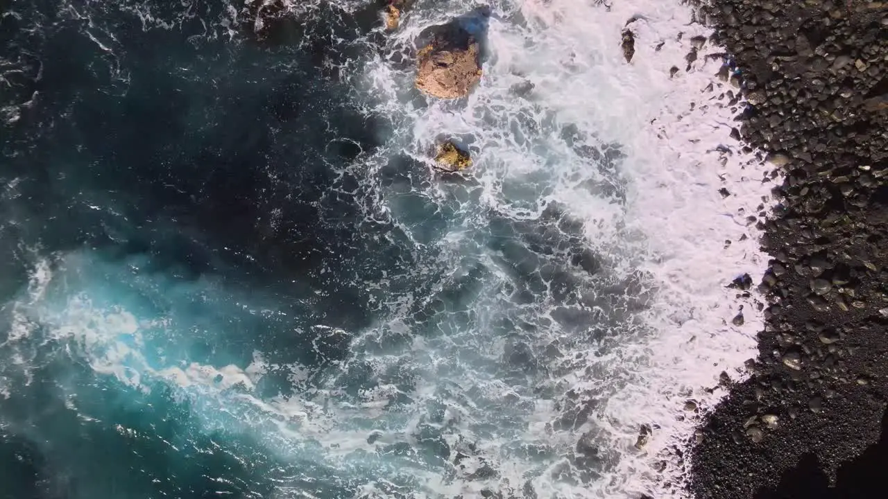 Spectacular aerial view captures the delicate encounter of calm ocean waves with the smooth cliffs of Big Island Hawaii