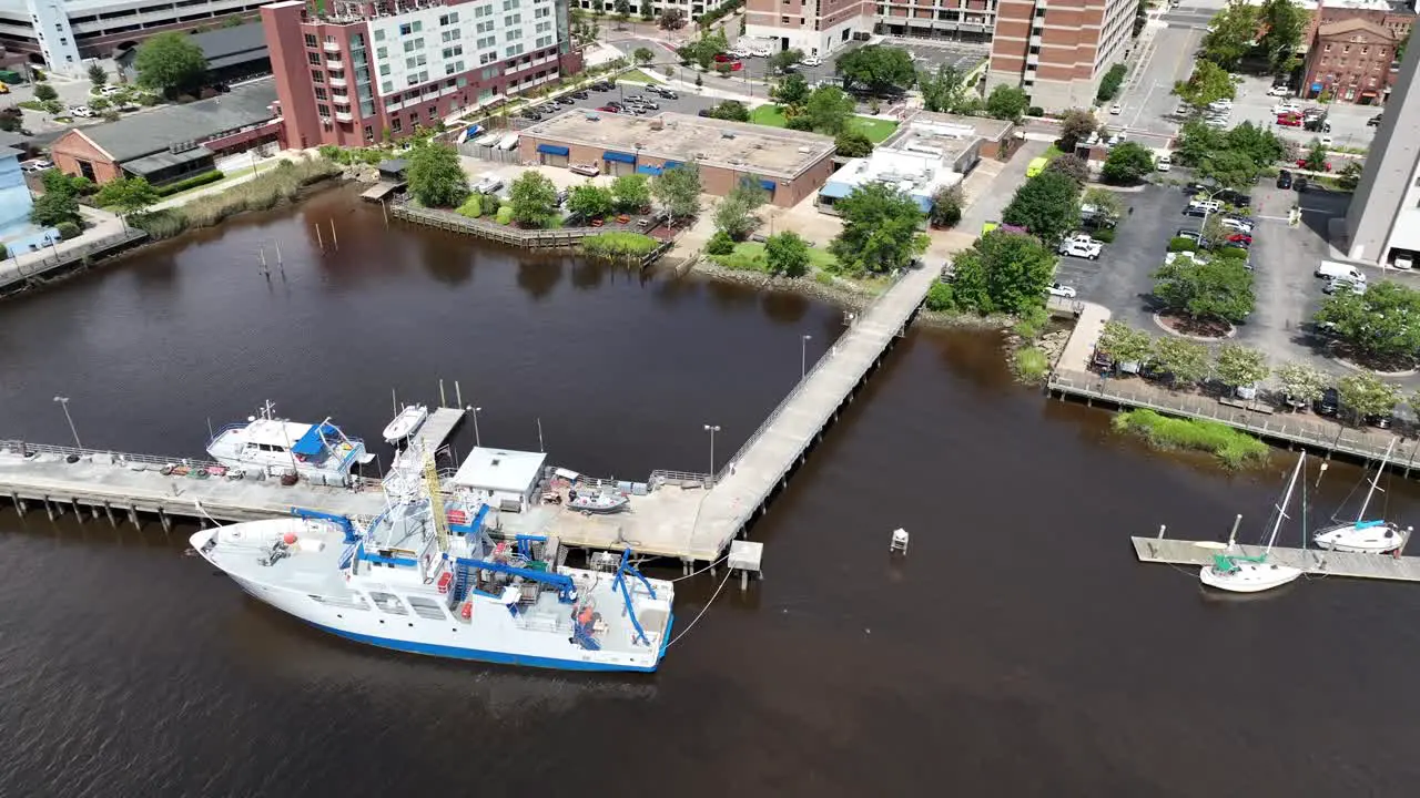 Embark on a voyage of scientific discovery with this captivating aerial view of an ocean research ship moored along the tranquil banks of a winding river