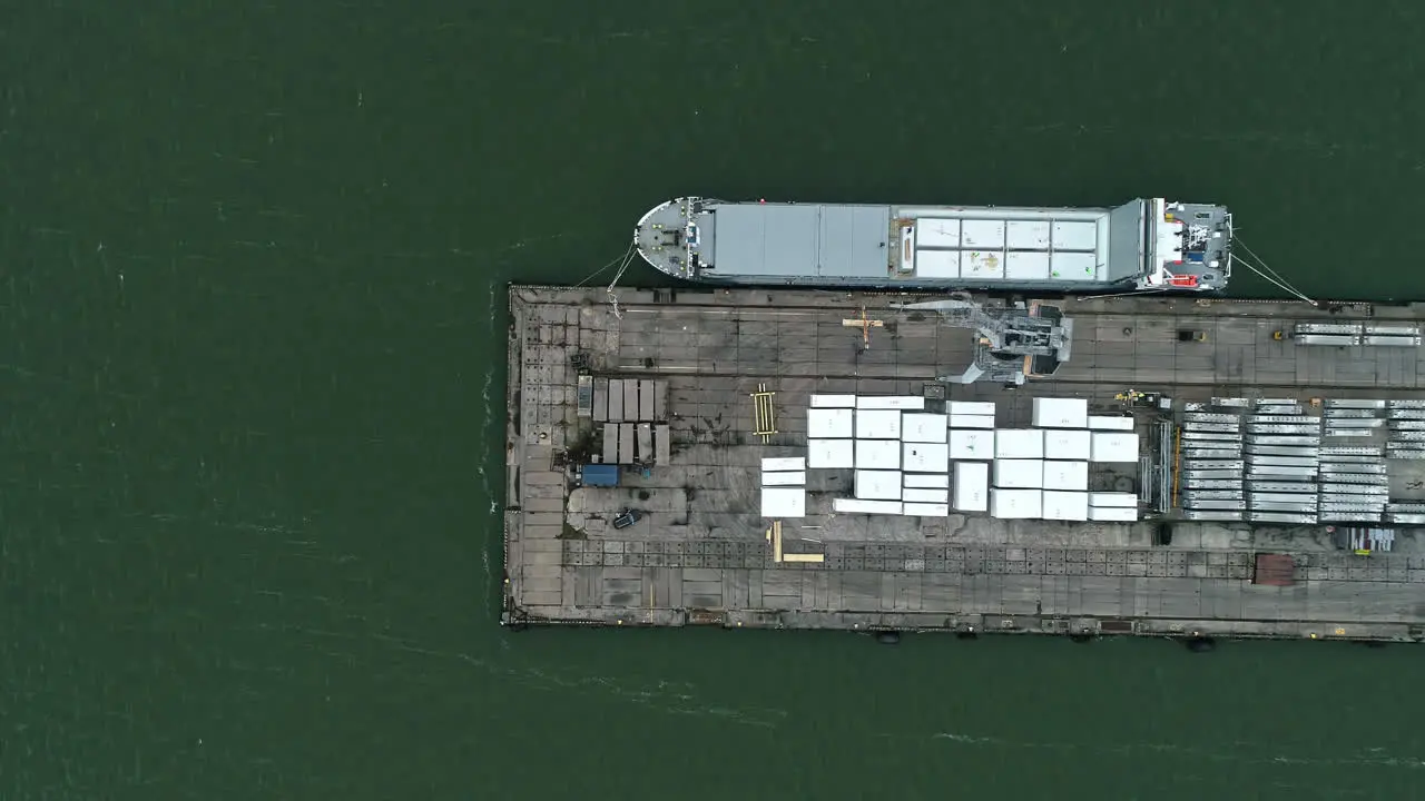 Aerial view of loading dock shipping containers with boat anchored waiting to be loaded