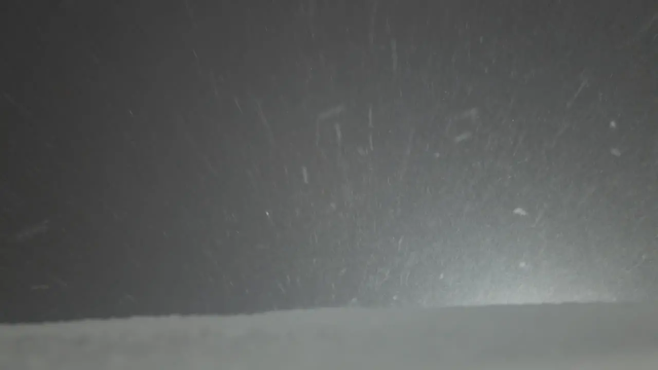 Tilted shot of snow falling at night