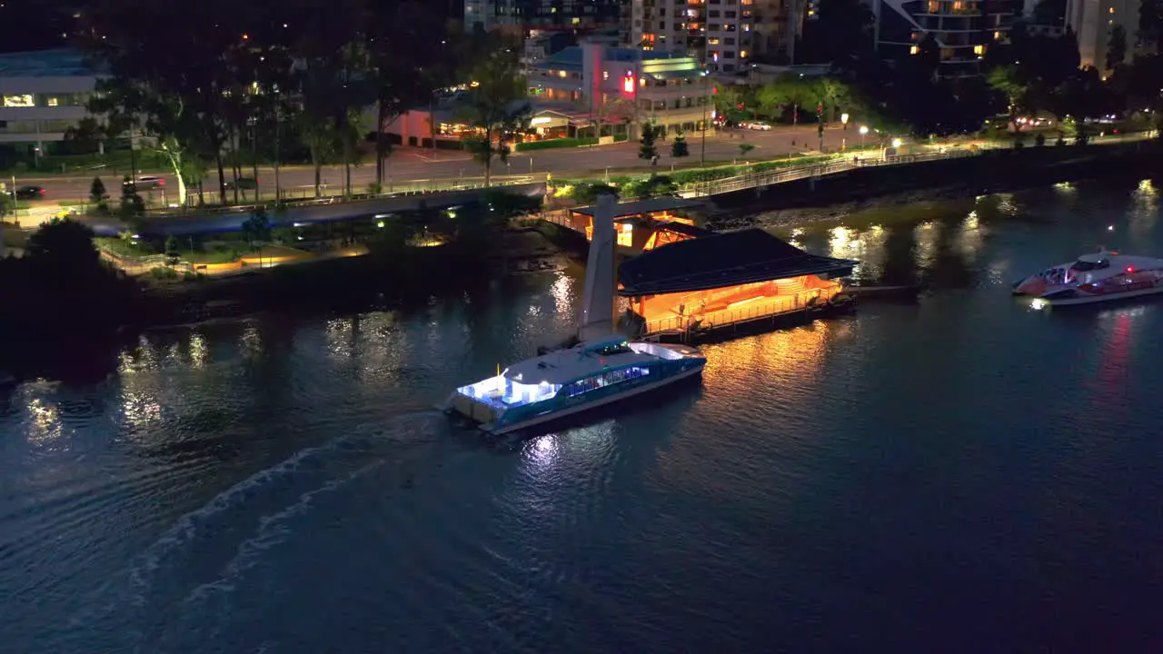 Aerial view of Brisbane City Ferry "CityCat" Arriving at "Regatta" terminal in Toowong after sunset