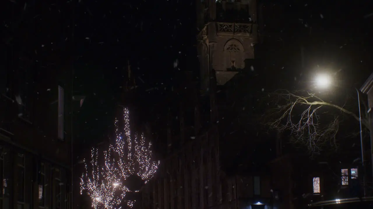 Winter snowfall in the night in Europe Netherlands Holland Dutch city town with lights and traditional architecture houses buildings