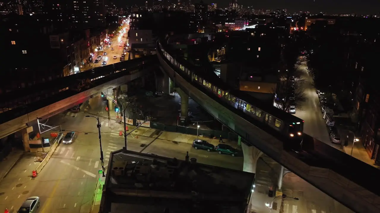 Aerial view of a CTA train on a bridge above the illuminated streets of Chicago