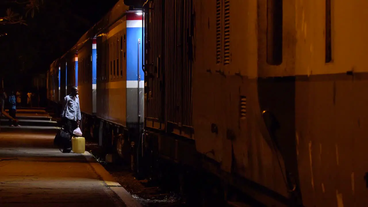 Passengers board a night train through Africa stopped at a station in Zimbawbwe