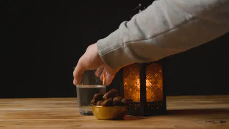 Tracking Shot of Hand Taking Glass of Water and Date On a Table for Ramadan