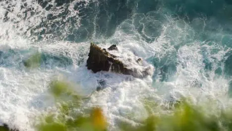 High Angle Shot of Waves Crashing Against a Rock On Uluwatu Coast