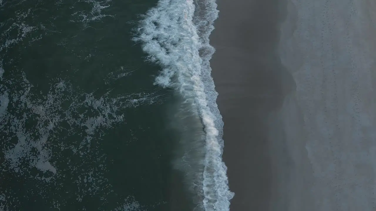 Vertical Shot Of Ocean Waves With White Foam Roll On Empty Sandy Shoreline At Long Beach Island In New Jersey USA