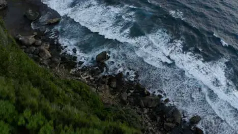 Drone Shot Flying Over Cliff Edge Looking at Waves 