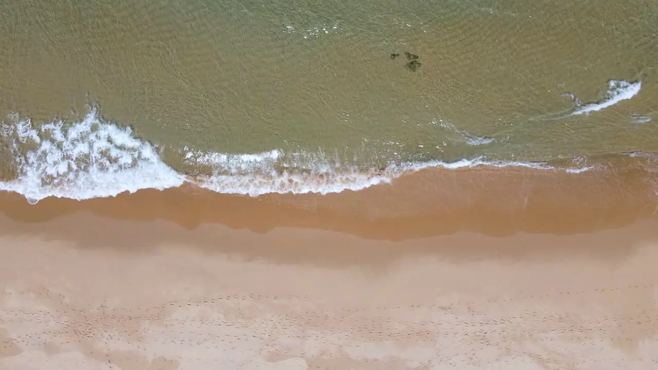 Birds eye view of a beach shore and its waves