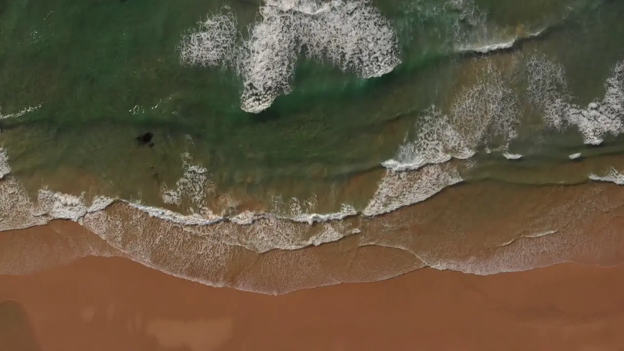 Atlantic ocean waves run out on golden sand beach