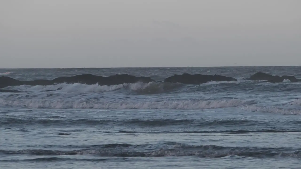 Early morning with tidal waves crashing on rocks and beach cinematic footage