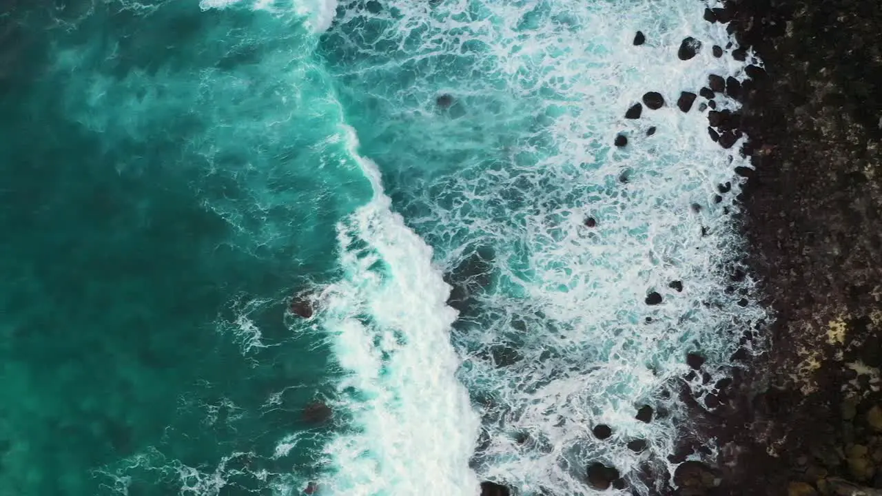 Aerial shot of turquoise ocean waves crashing black sand coastline of Nusa penida island one of the tourist attractions of Bali island Crystal beach kelingking beach angle billabong broken beach