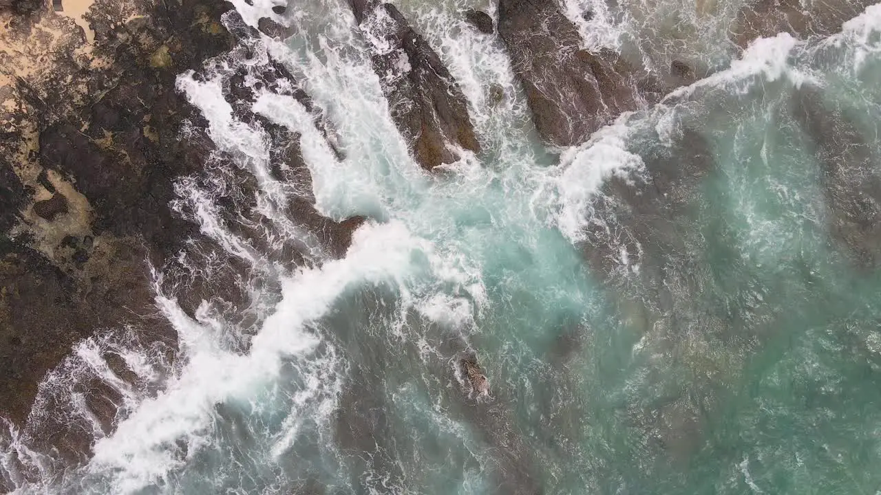 Overhead view of waves on rocky shore in Hawaii static