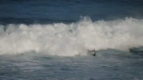 Long Shot of Waves Crashing Over Surfers in Bali