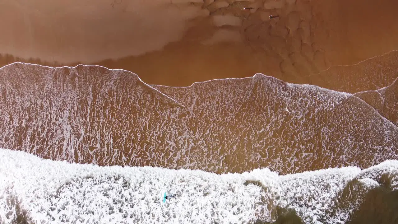 Stunning Aerial Shot of Surfers and Waves Crashing on Tynemouth Long Sands Beach