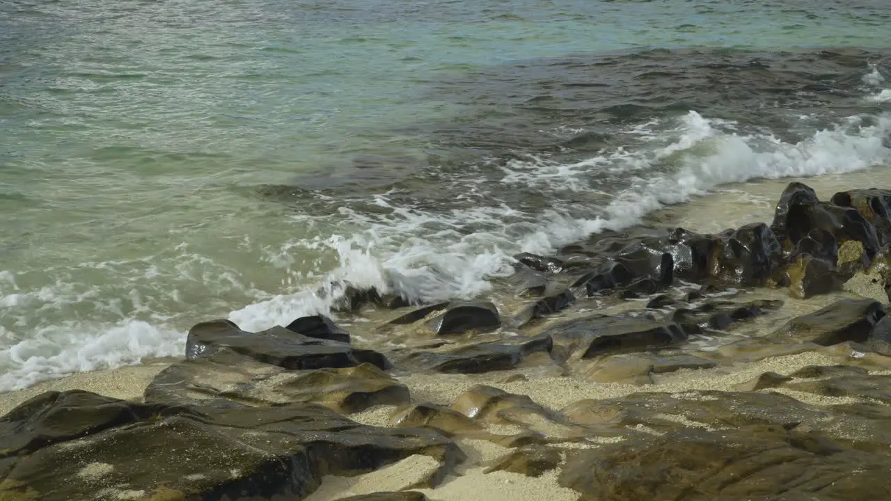 Gentle waves breaking on rocky coast of tropical island in Fiji