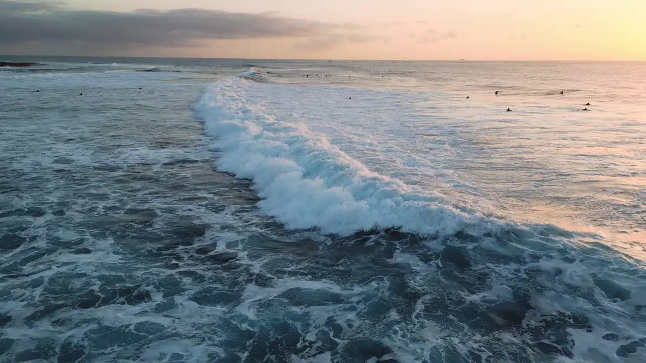 Aerial view of a breaking wave at sunset