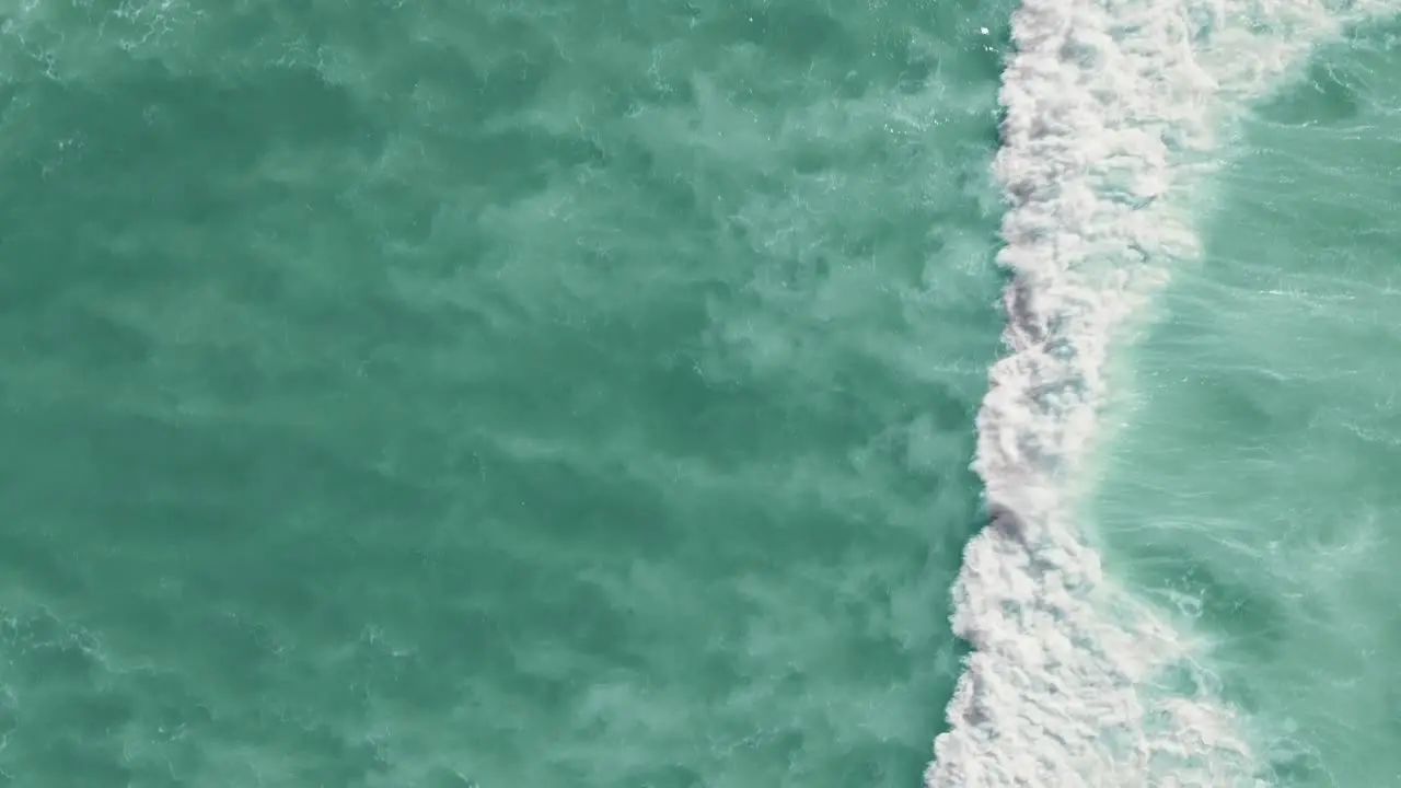 Drone shot of waves crashing in the ocean