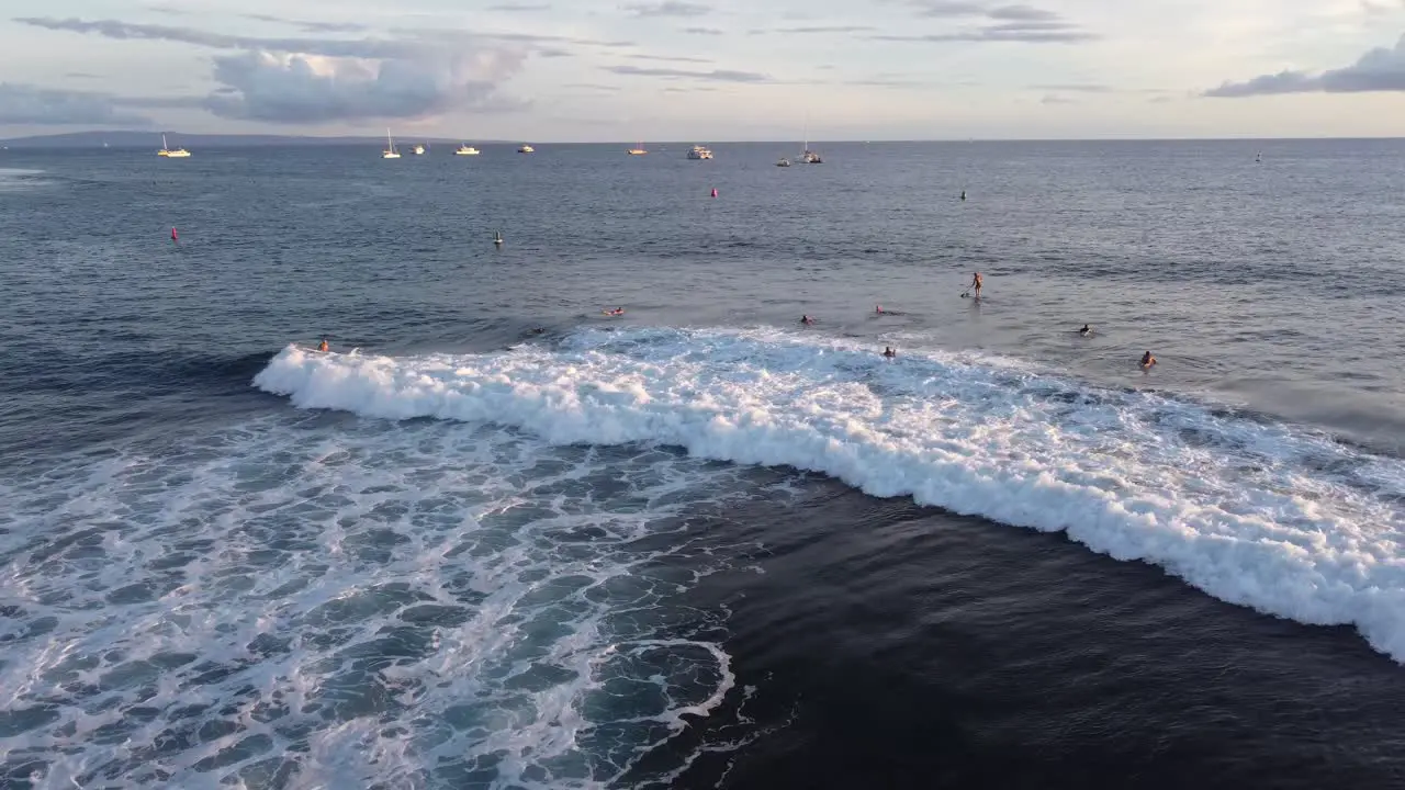 Beautiful scenary of surfers catching waves with amazing view in the back in Hawaii