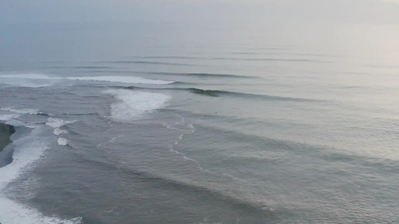 Pacific Ocean waves crashing against Mexican shoreline 4K sunset aerial view