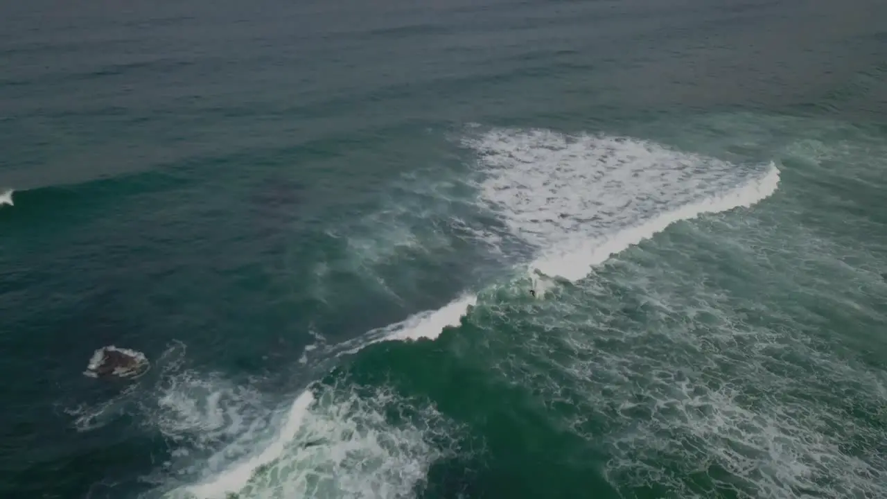 Lonely Surfer surfing great waves in abano Beach Portugal Static Drone Aerial