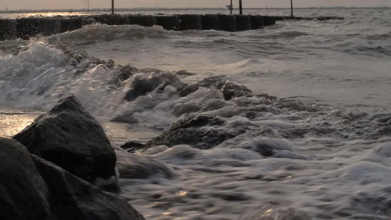 close up of small rocks on beach pier late afternoon