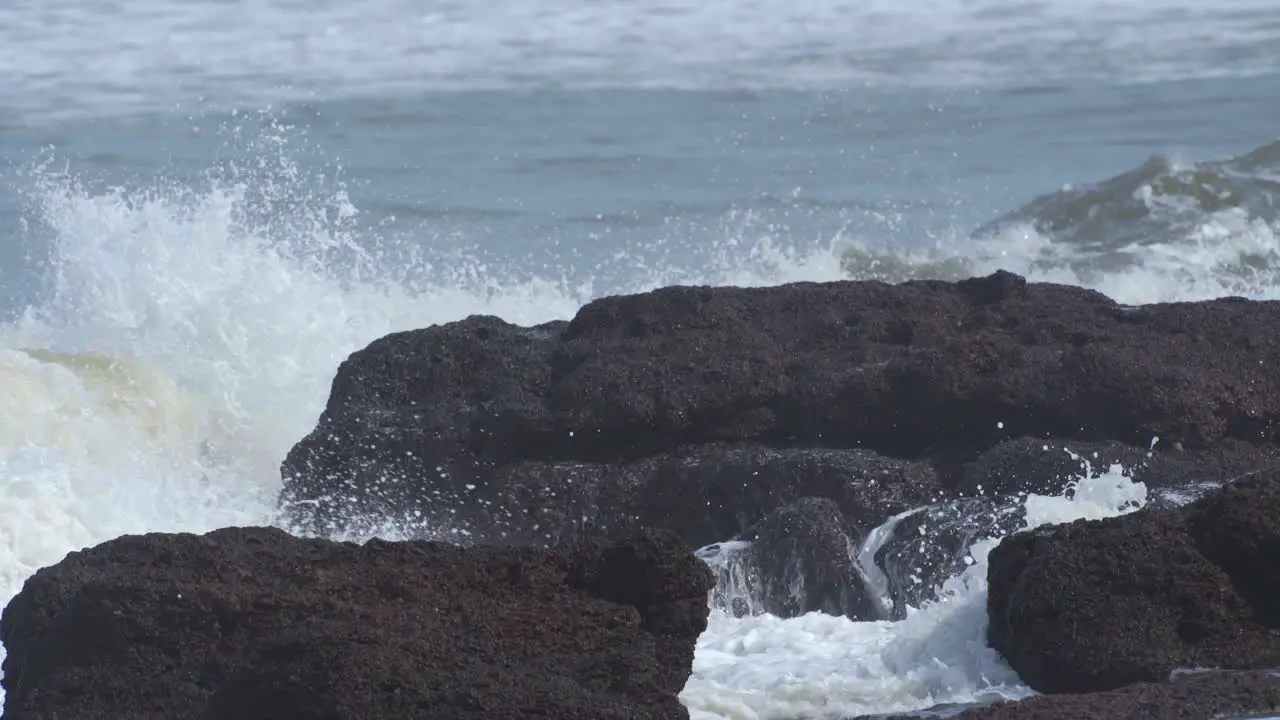 Sea waves hitting the rock in slow motion at sunset