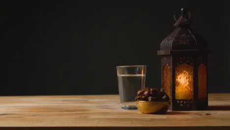 Tracking Shot of a Lantern Water and Dates On a Table for Ramadan