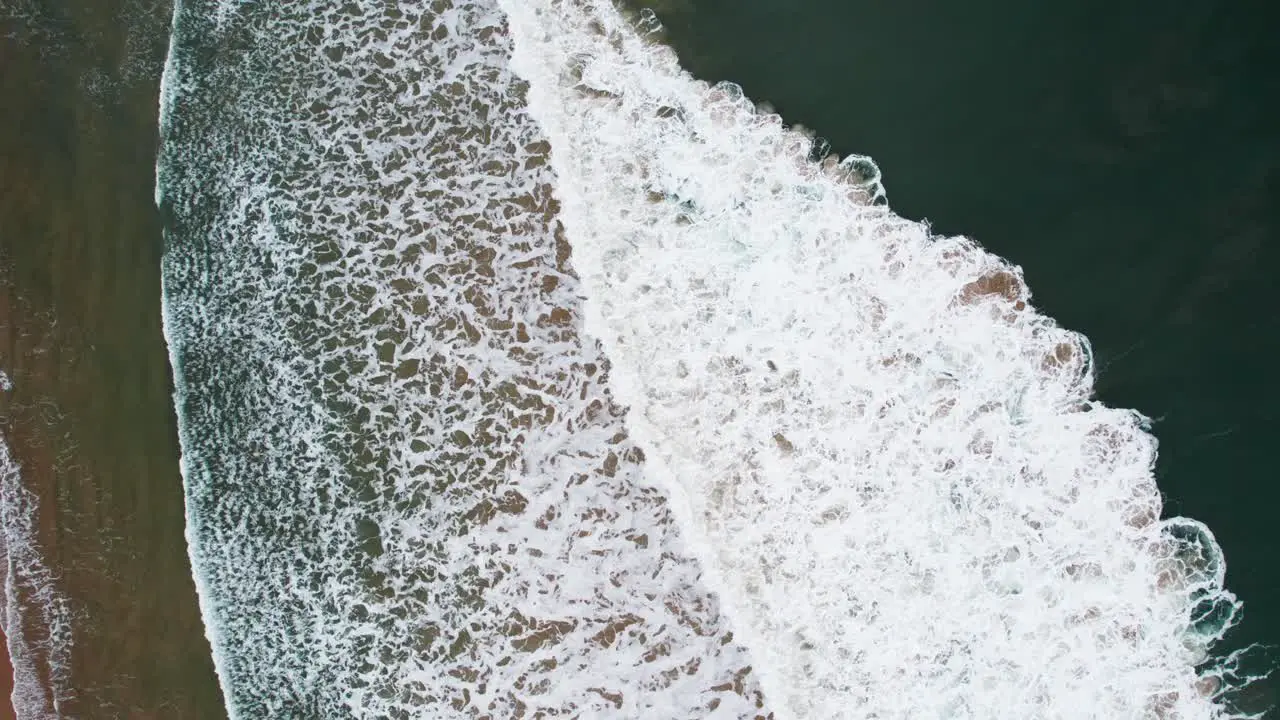 Aerial footage of breaking waves top-down view