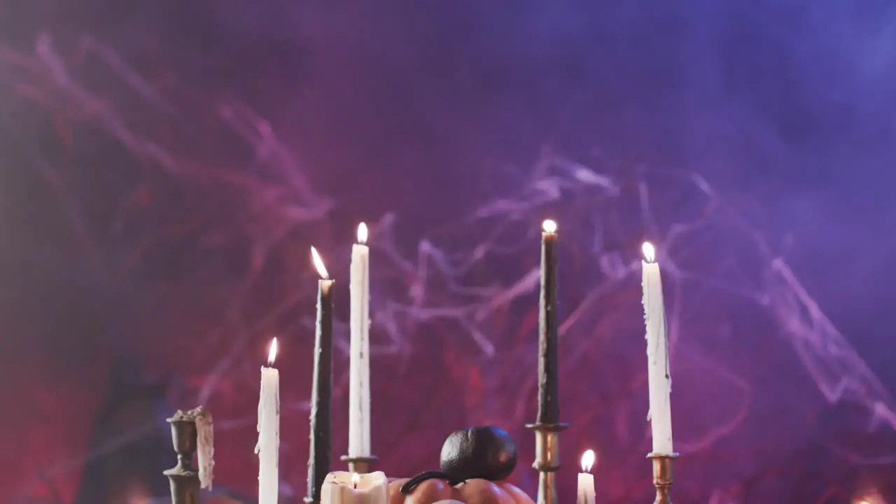 Video of halloween skull candles and smoke with copy space on purple background