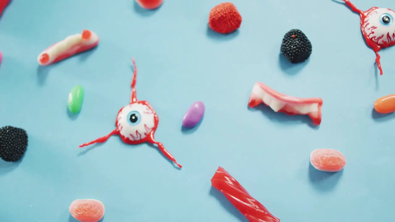 Close up view of multiple halloween toys and candies against blue background