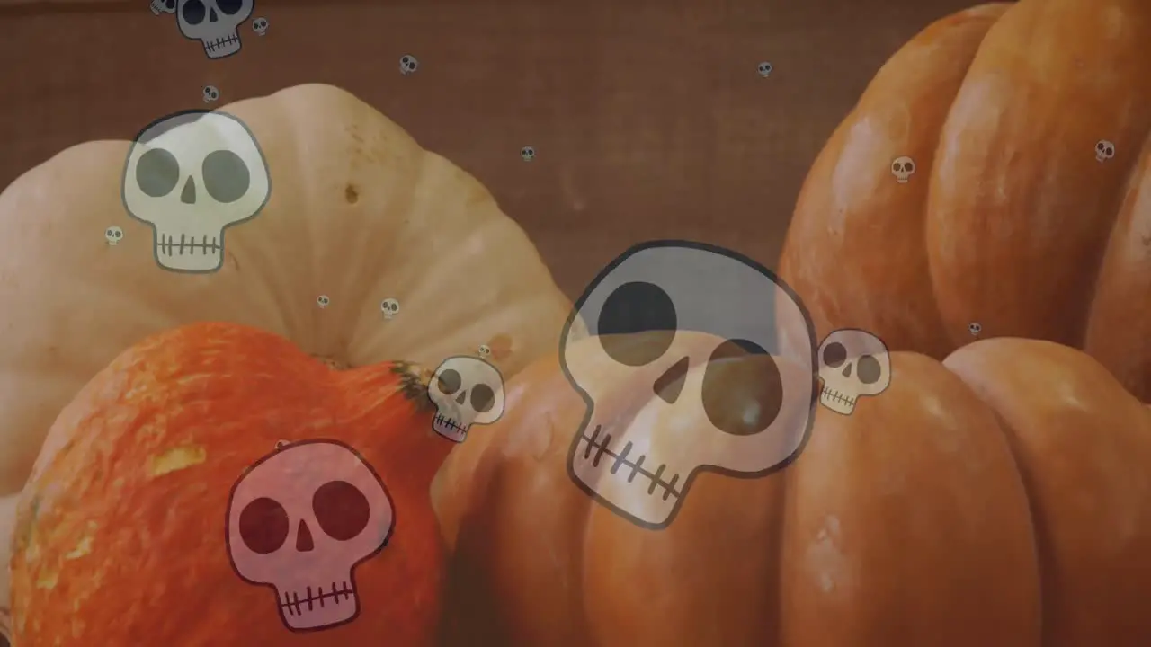 Animation of happy halloween text over skulls and pumpkins