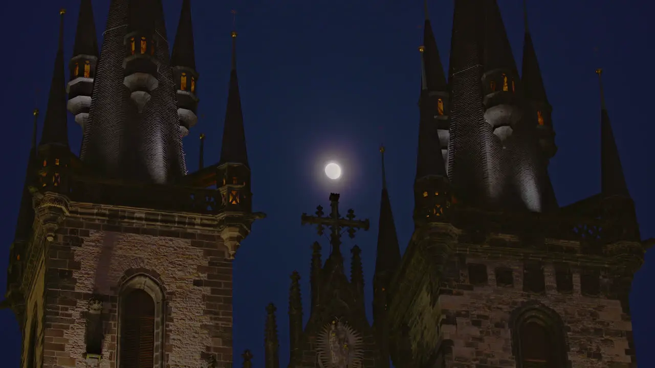 Full moon shining between Prague Church of Our Lady before Tyn spires