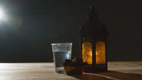 Stationary Shot of Lantern Water and Dates On Table for Ramadan