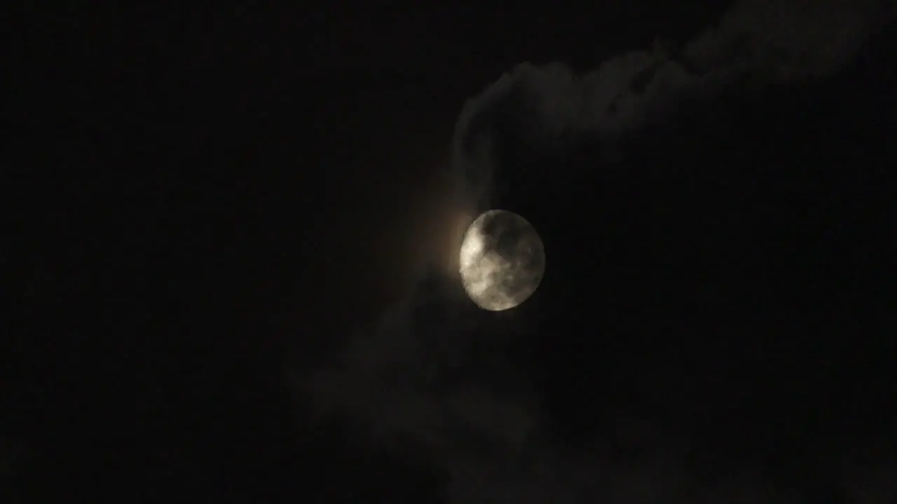 Timelapse of the full moon rises from behind the clouds