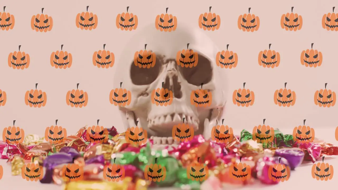 Animation of pumpkins over skull and sweets on white background