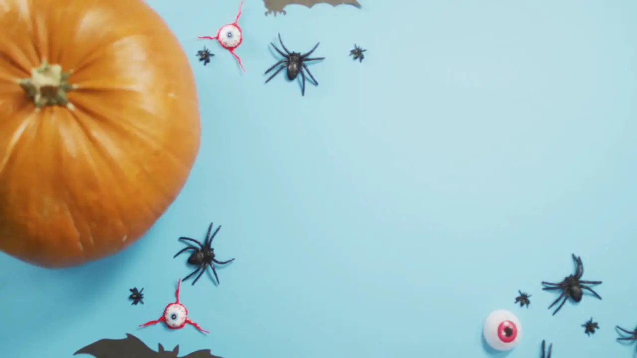 Close up view of pumpkin and halloween toys against blue background