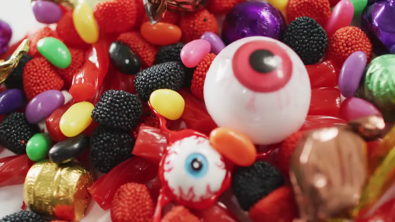 Close up view of variety of halloween candies fallen against grey background