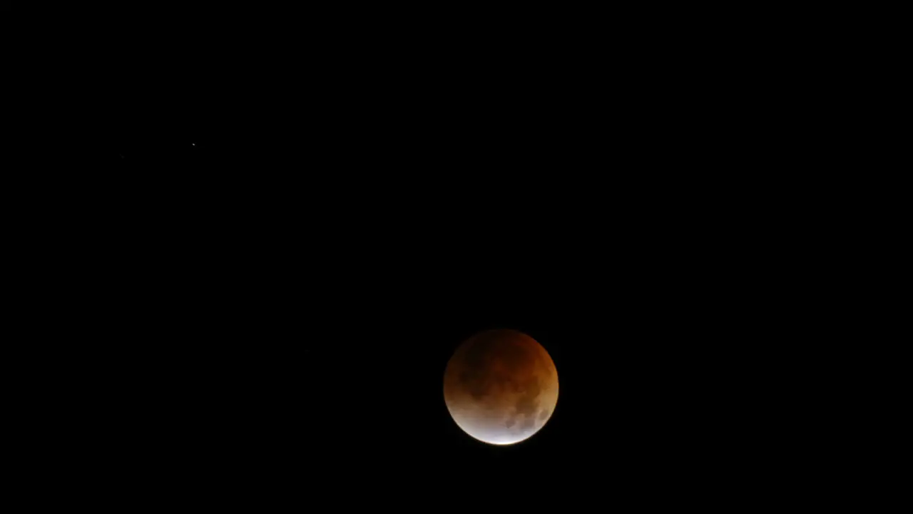 Time lapse of a lunar eclipse with moon moving across frame