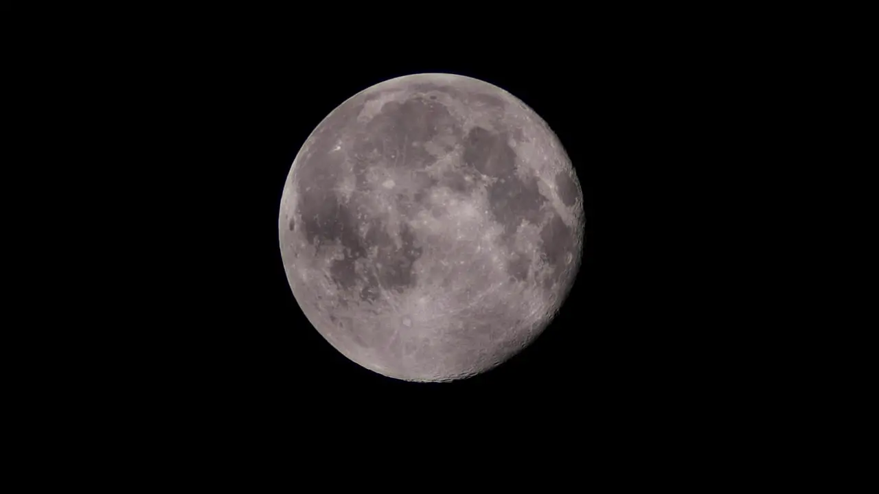 Full super winter moon in cloudy night sky slow motion