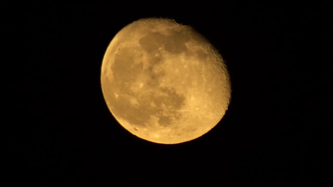 Extreme Close Up Of Orange Third-Quarter Moon On A Clear Night