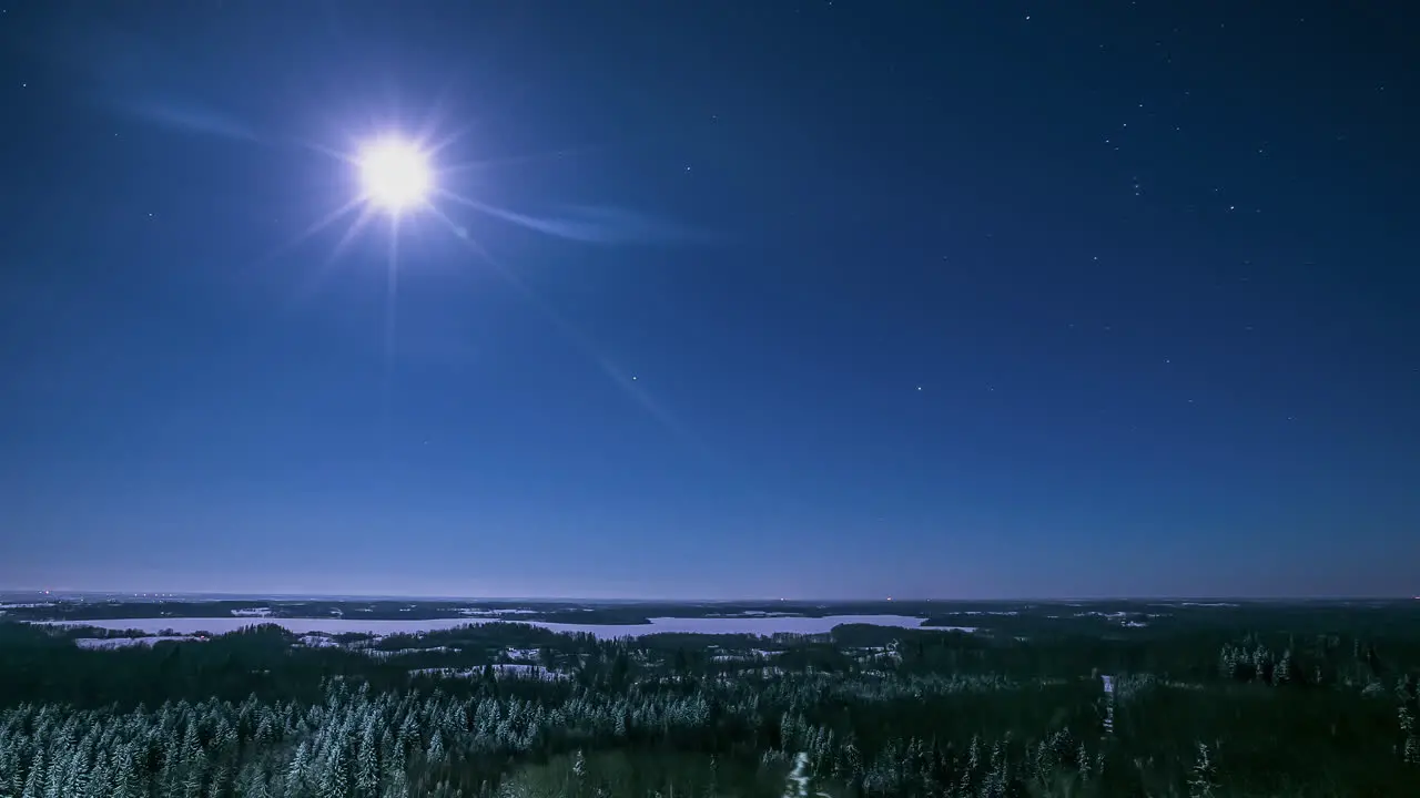 Moon and stars over a winter landscape wilderness nighttime time lapse